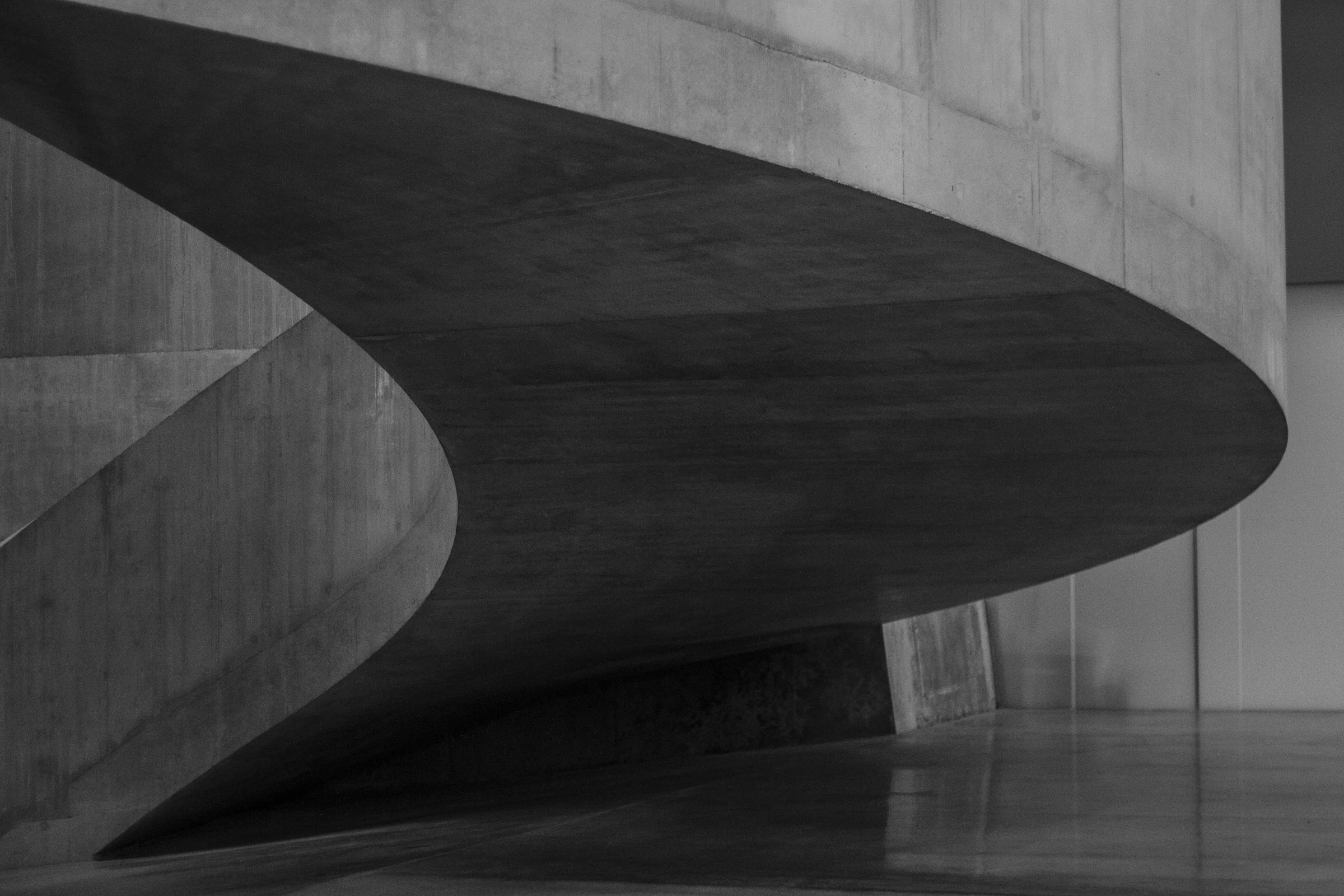 A sculptural staircase curving through light and shadow